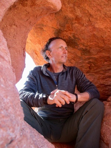 Closeup of Dr. Dave sitting under a red rock cave